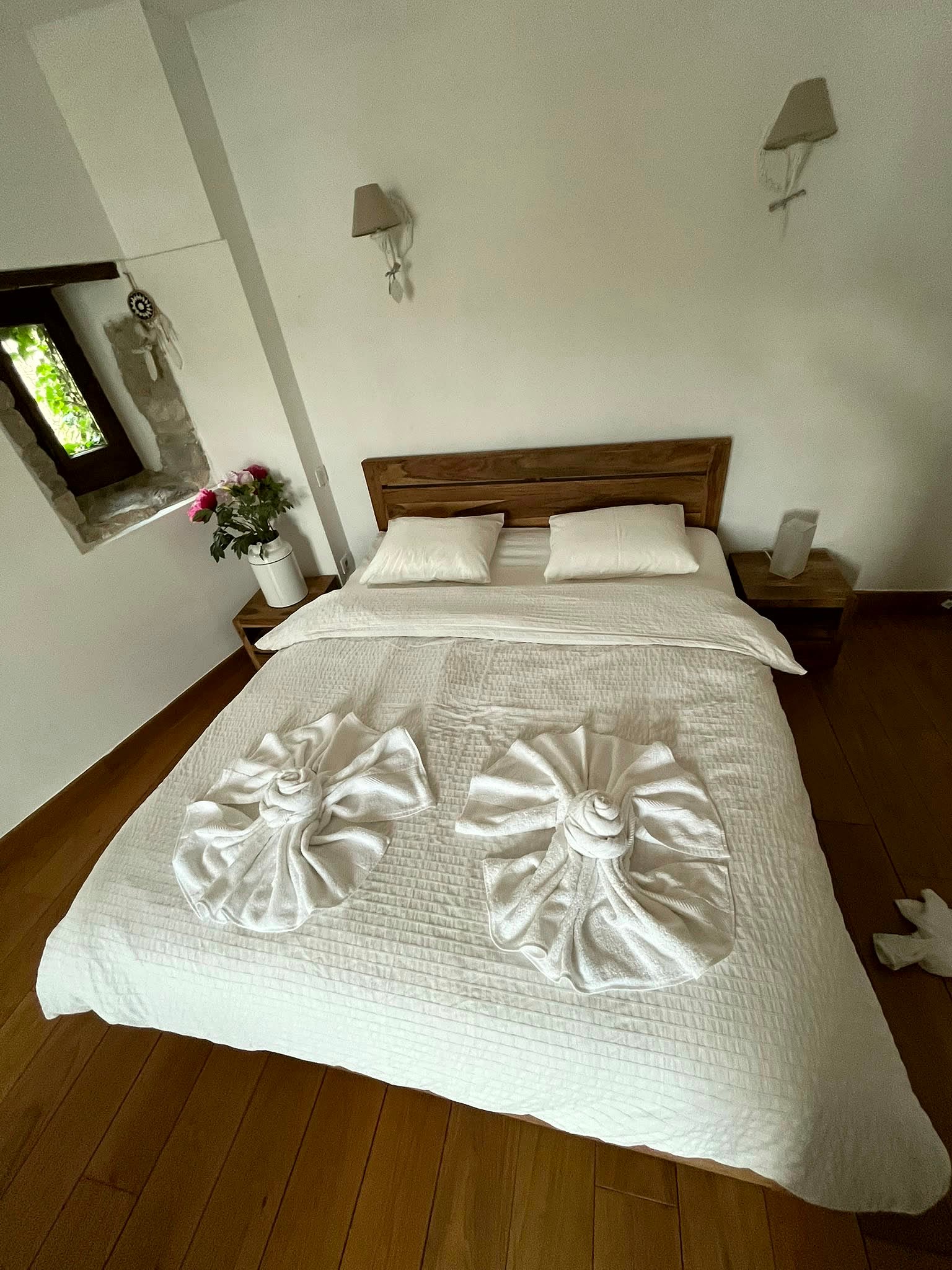 Chambre d'un logement en location courte durée remise en état, linge plié en fleur sur le lit