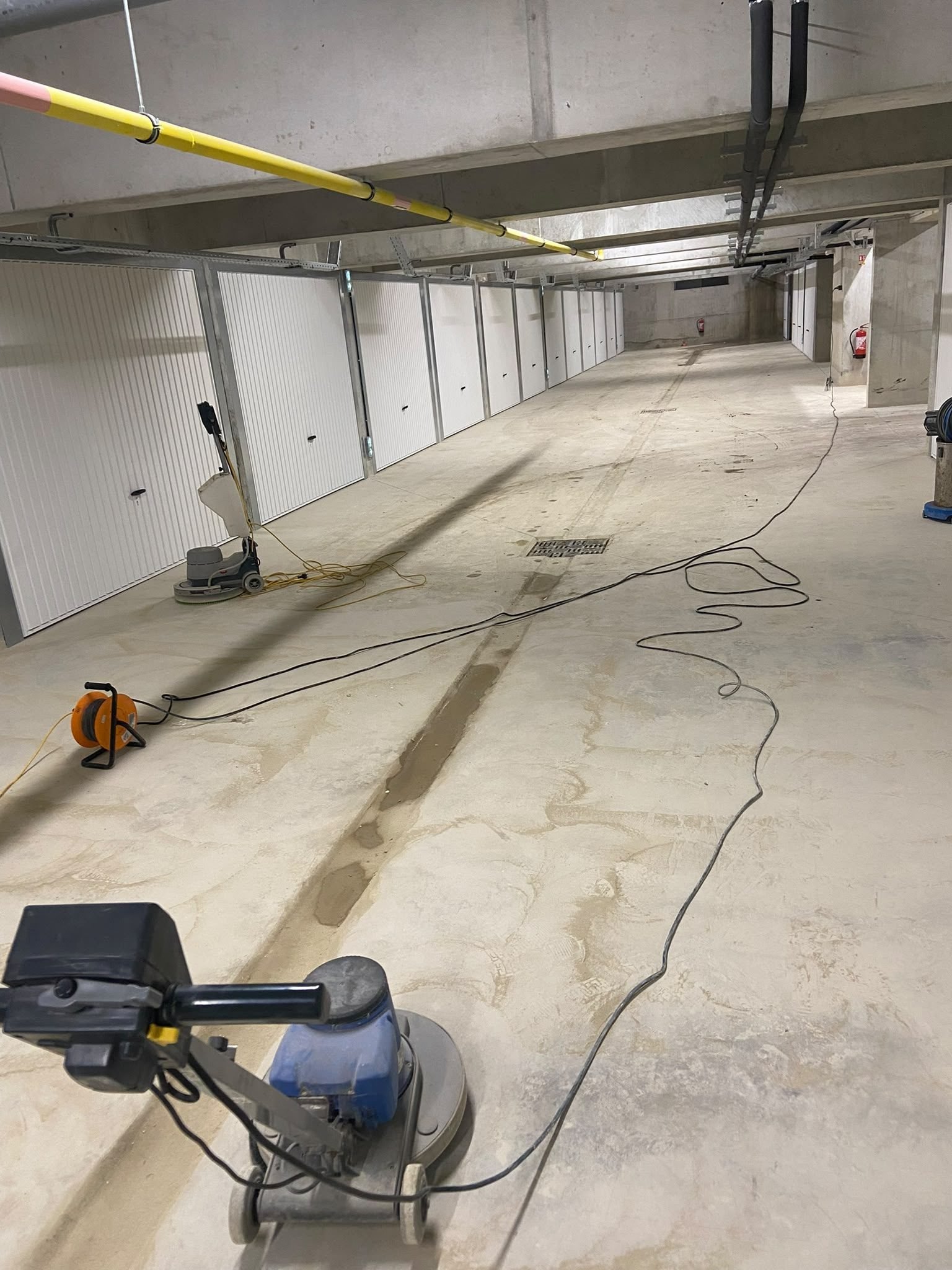 Monobrosse professionnelle en action sur le sol béton d'un chantier en fin de travaux