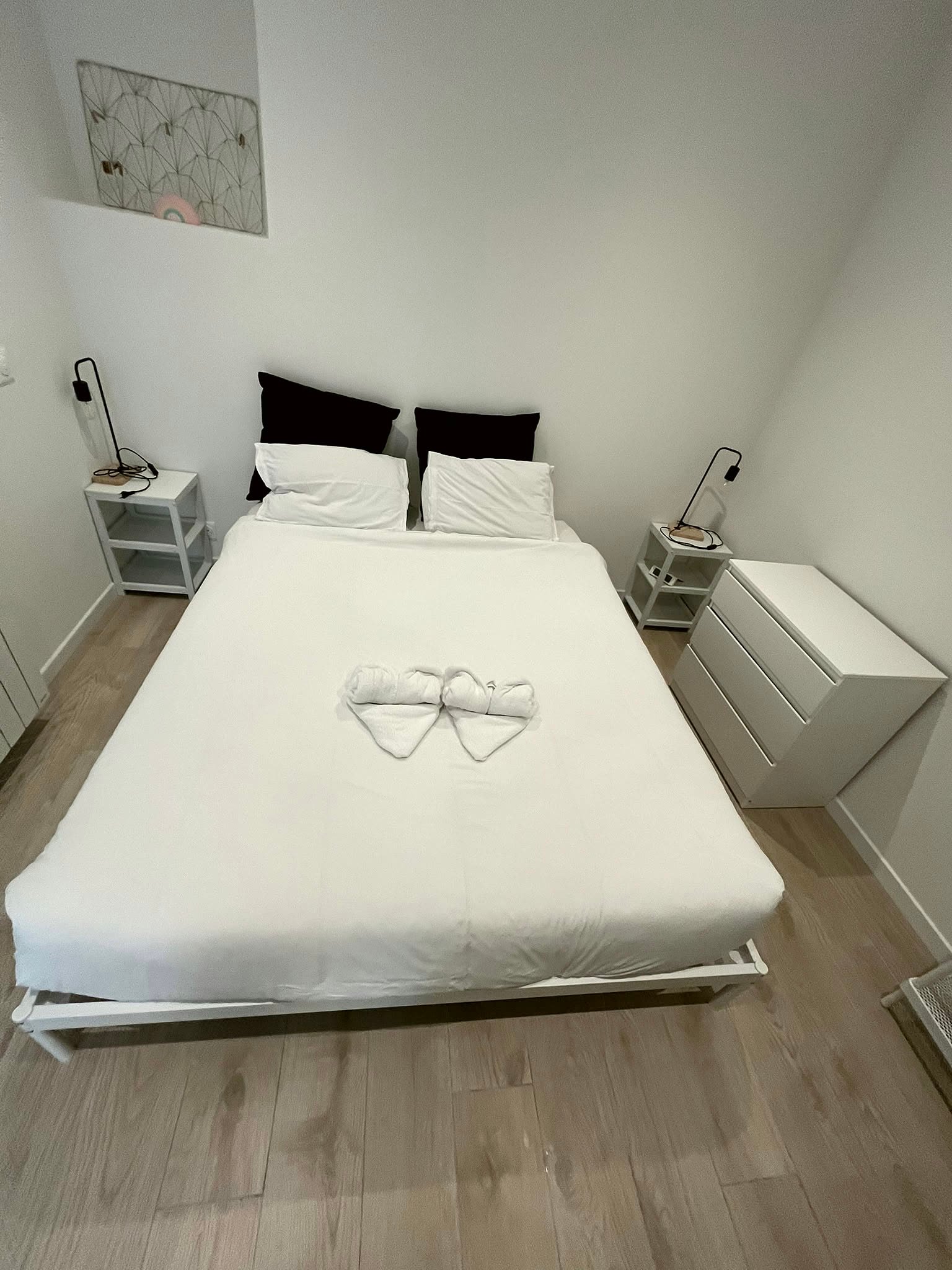 Lit double préparé avec linge propre et serviettes pliées