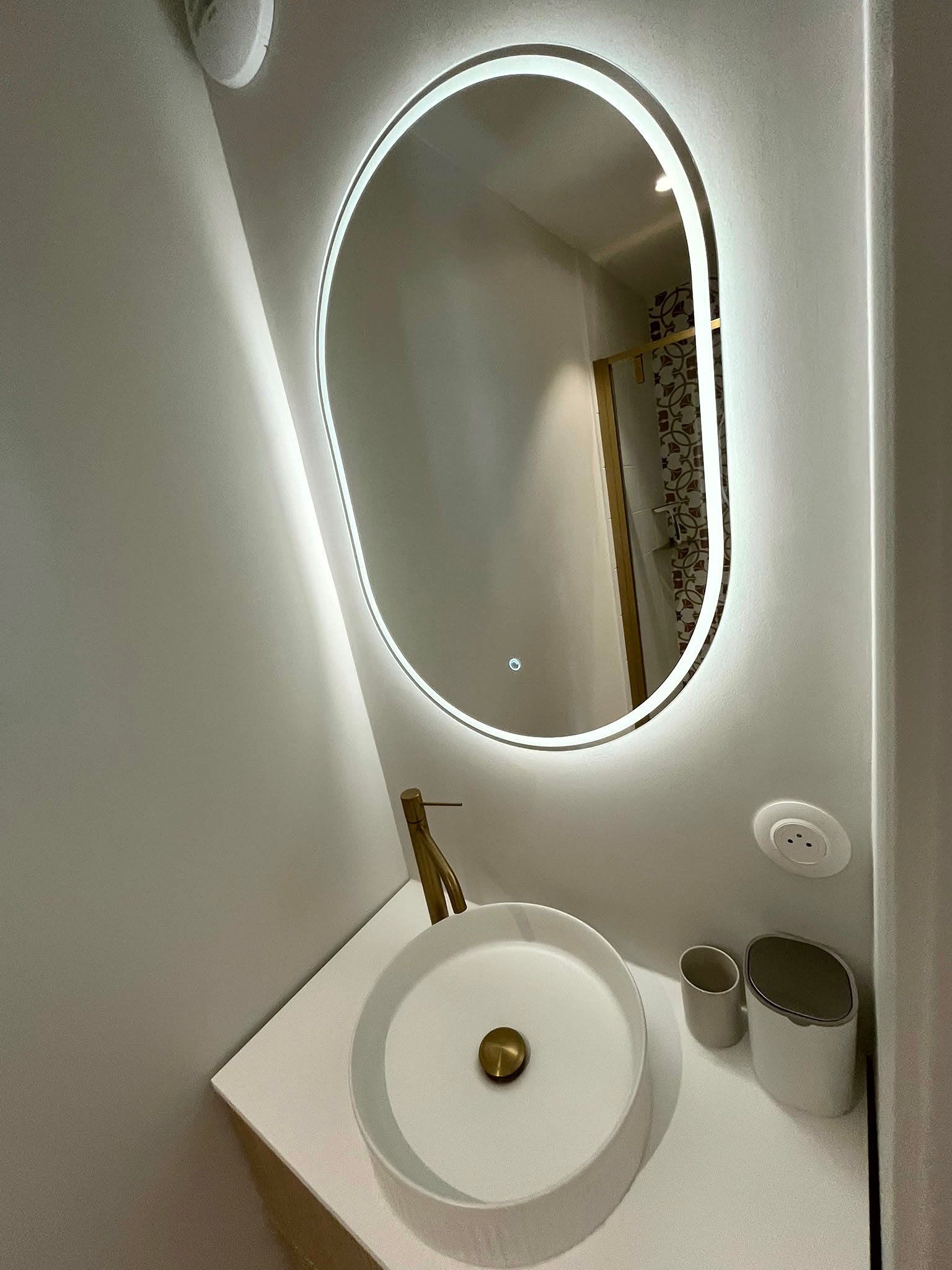 Vasque, miroir ovale et robinetterie dorée détartrés