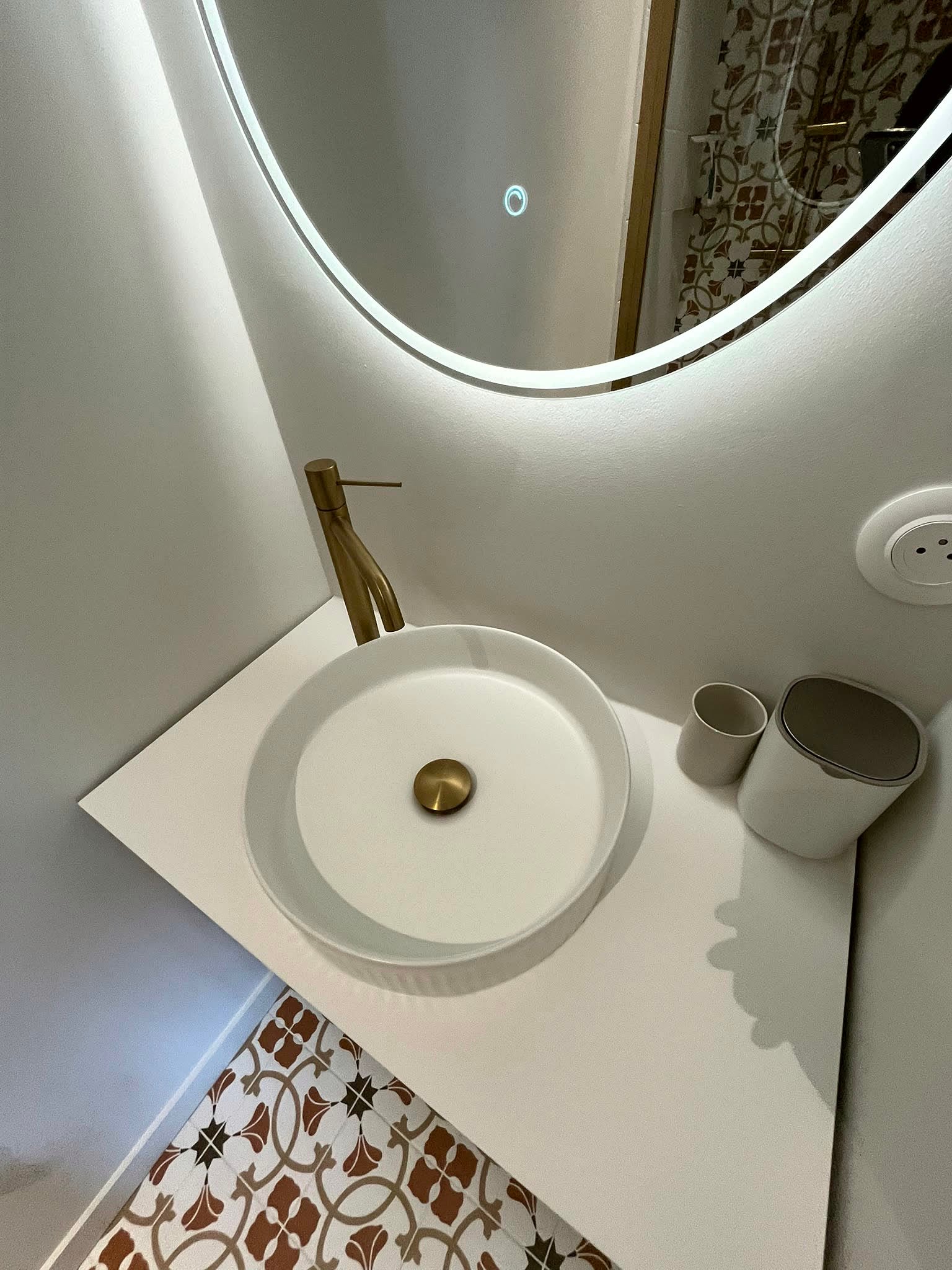 Salle de bain avec vasque et robinetterie dorée, nettoyée dans le détail