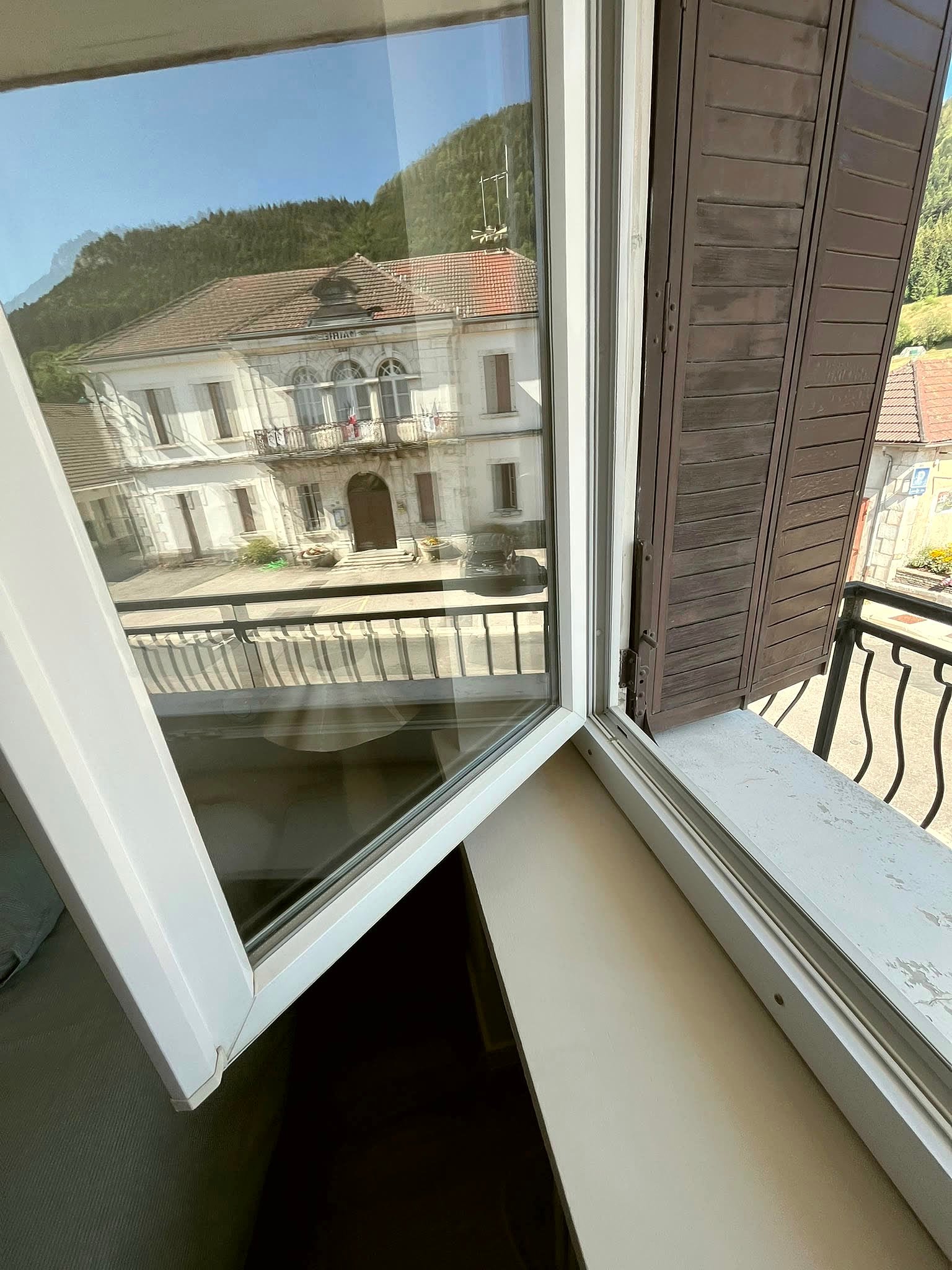 Fenêtre nettoyée donnant sur un village, vitrage sans traces